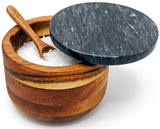 Wooden salt cellar with marble lid and wooden spoon, filled with coarse sea salt