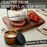 Acacia wood salt cellar with spoon, cutting board, burger press, tomatoes and peppercorns.