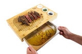 Bamboo carving board with juice tray, sliced steak, and condiment bowls