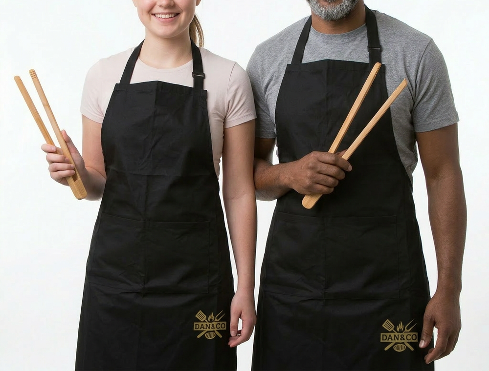 Two people wearing black aprons and holding bamboo kitchen tongs, white background