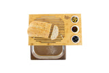 Bamboo bread cutting board with tray, olives, oil, and fresh bread on white background