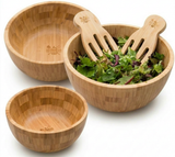 Set of three bamboo salad bowls with salad servers and fresh greens