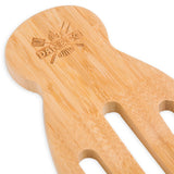 Close-up of a bamboo wooden salad server with engraved details and slotted design